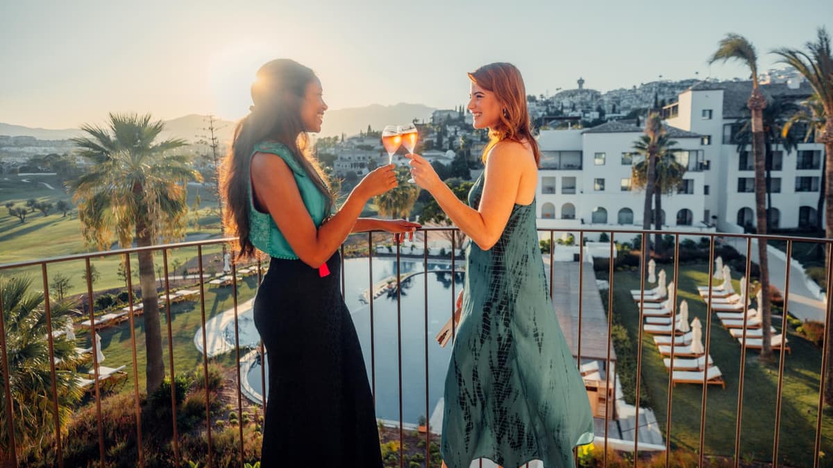 women-toasting-balcony women-toasting-balcony