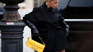 Caro Daur mit einer gelben Designer-Handtasche