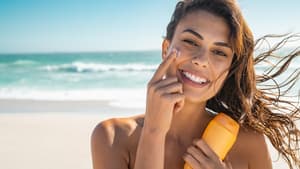 Frau Auftrag Sonnencreme am Strand