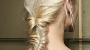 Frau mit blonden Haaren und Fischgrätenzopf