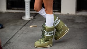 Frau trägt grüne Moon Boots mit weißen Socken