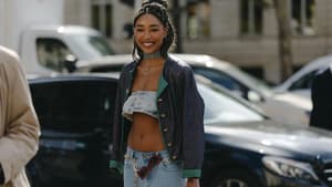 Frau lacht trägt Jeans Look und Jacke Gürtel Sonnenbrille
