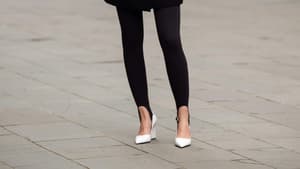 Erna Leon trägt schwarze Leggings mit Steg weiße Heels und schwarzen Blazer