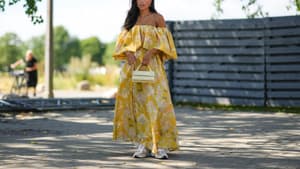 Frau im gelben floralen Maxi-Kleid