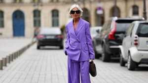 Frau mit violettem Hosenanzug und grauen Haaren