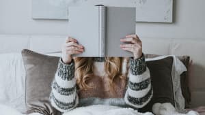 Frau liest ein Buch im Bett