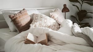 Bett mit weißer Bettwäsche im Schlafzimmer