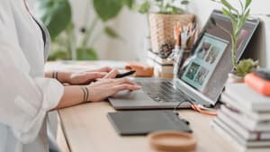 Frau mit weißem Hemd arbeitet am Laptop