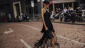 Frau in schwarzem Kleid mit Fransen