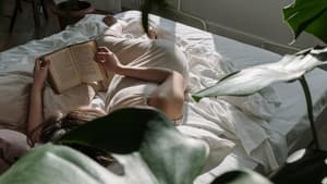 Frau liest Buch im Bett
