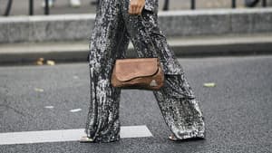 Frau trägt auf Paris Fashion Week schimmernde Hose in Silber