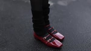 Frau trägt rote Lack-Ballerinas