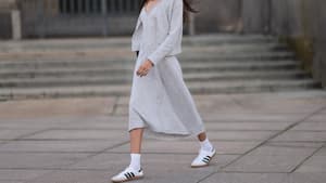 Frau trägt Kleid und weiße Sneaker