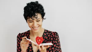 Frau öffnet eine Karte mit Herz