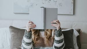 Frau mit Buch im Bett