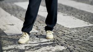 Frau mit schwarzem Outfit und Sneakern