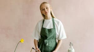 Frau mit grüner Schürze backt Kuchen