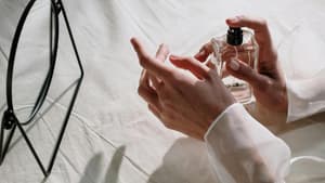 Frau trägt Parfum auf Handgelenk auf