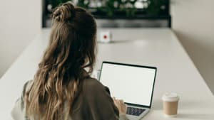 Frau sitzt vor ihrem Laptop