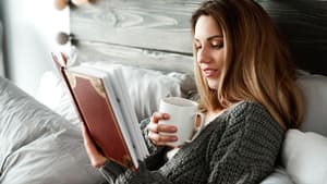 Frau liest Buch im Bett