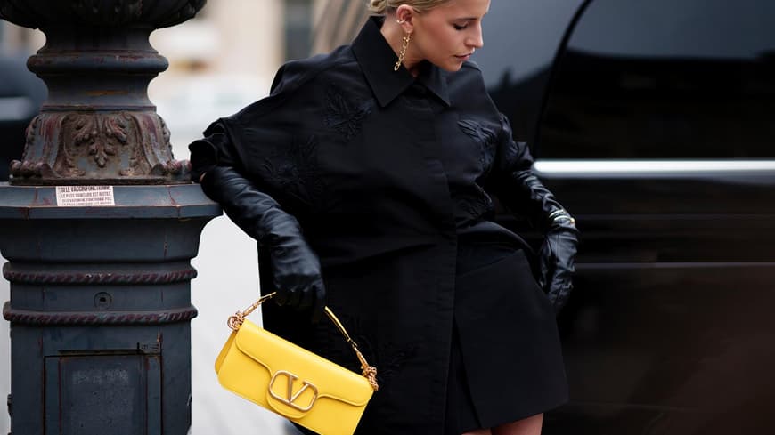 Caro Daur mit einer gelben Designer-Handtasche