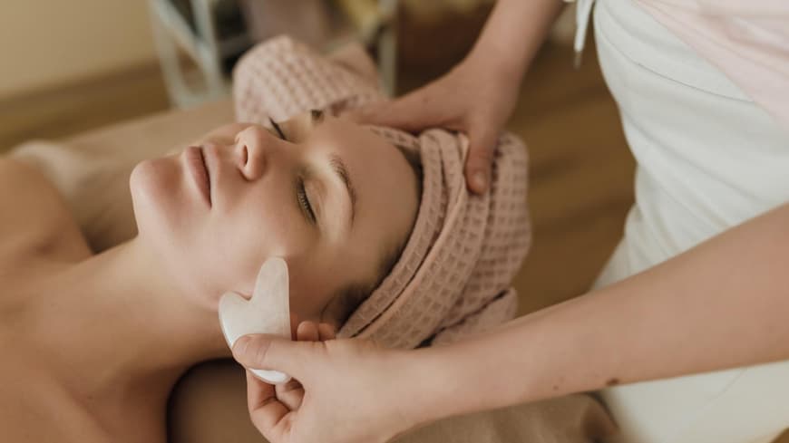 Frau bekommt eine Gua Sha Stein Anwendung
