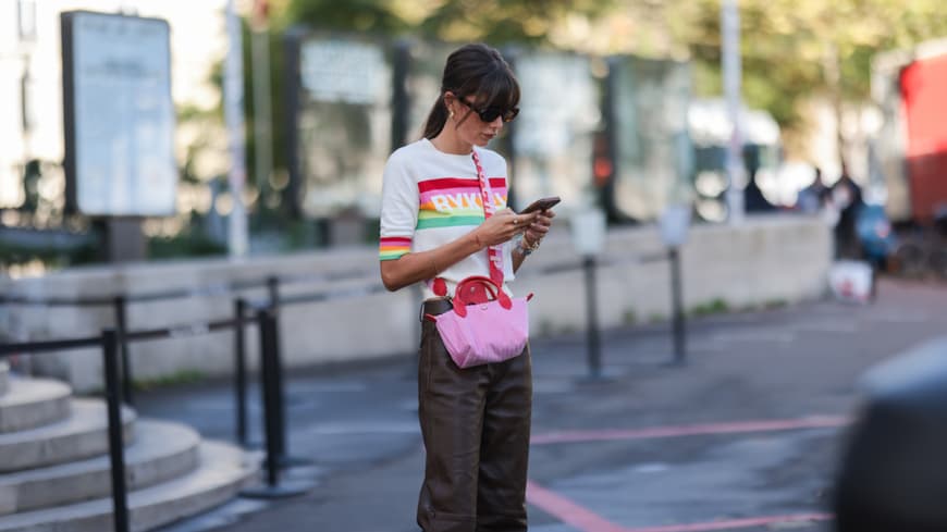 Stylische Frau schaut auf ihr Handy
