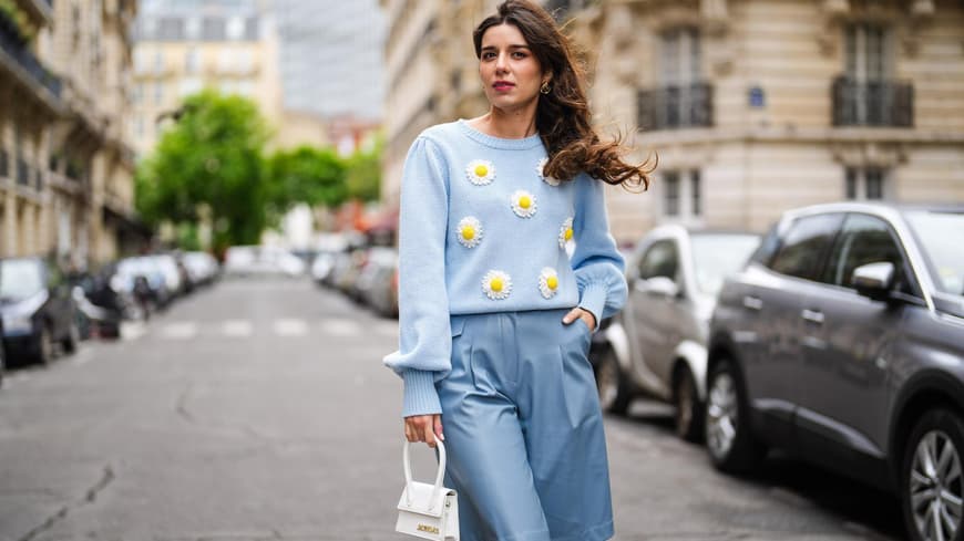 Frau trägt blaue Stoff-Bermuda-Shorts mit passendem Pullover