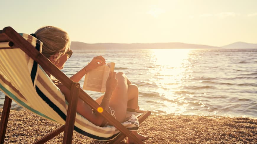 frau liest buch Strand Liegestuhl