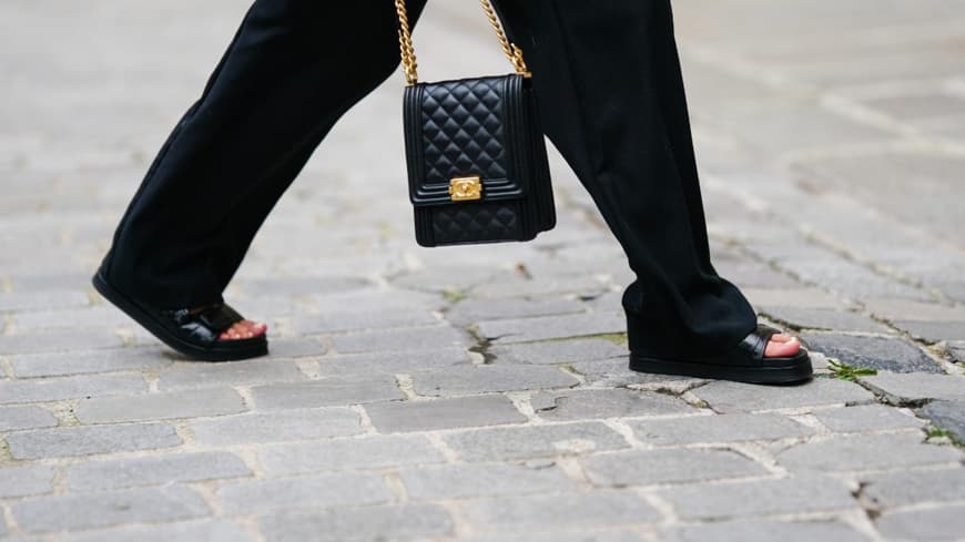 Frau trägt schwarze Sandalen schwarze Tasche und Hose Streetstyle