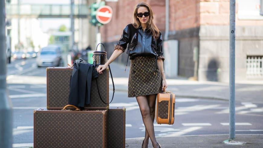 Frau mit Louis Vuitton Koffern und Taschen auf der Straße