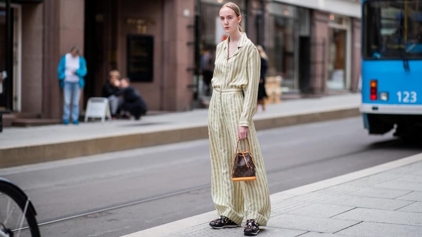 Eine Frau trägt eine Sac Noé Tasche von Louis Vuitton