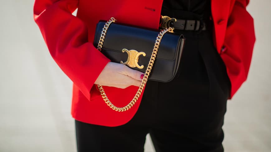 Frau mit rotem Blazer und schwarzer Celine Triomphe Tasche