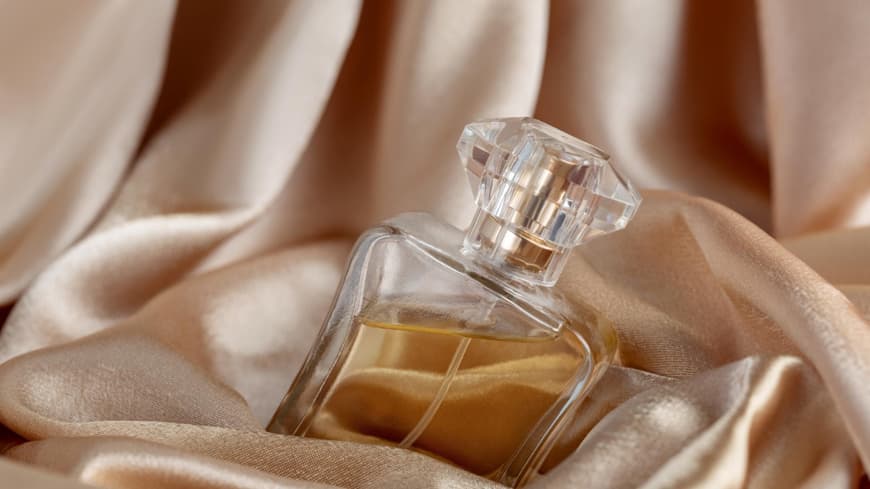 Glasflasche Parfüm auf goldene Seide Hintergrund