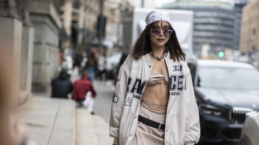 Mailand Fashion Week Streetstyle Frau trägt BH beige Rock beige Racing Jacke