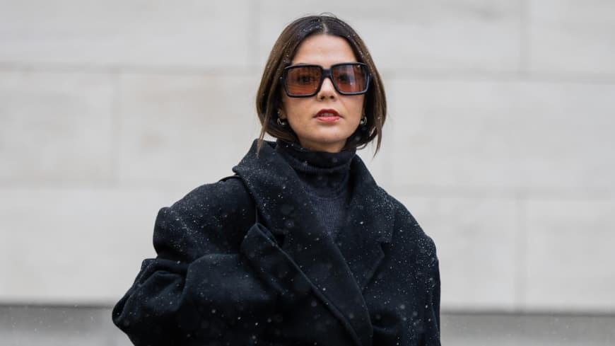 Amelie Stanescu trägt schwarzen Mantel Tasche und Sonnenbrille