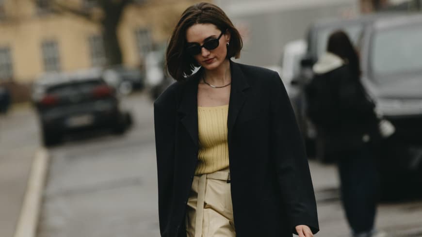 Frau trägt Oversize Blazer in schwarz weite Hose in Creme