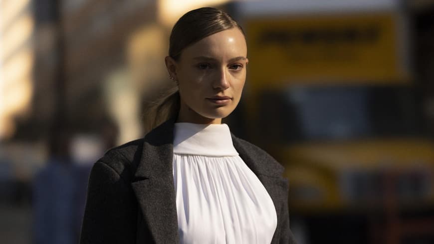 Frau trägt weißes Kleid und schwarzen Mantel New York Fashion Week 