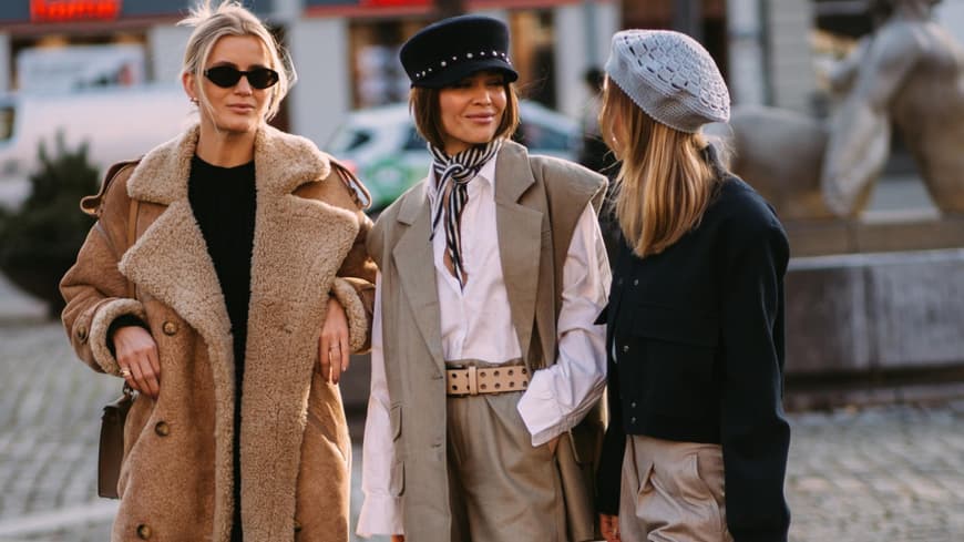 Drei stylische Frauen unterhalten sich auf der Fashion Week