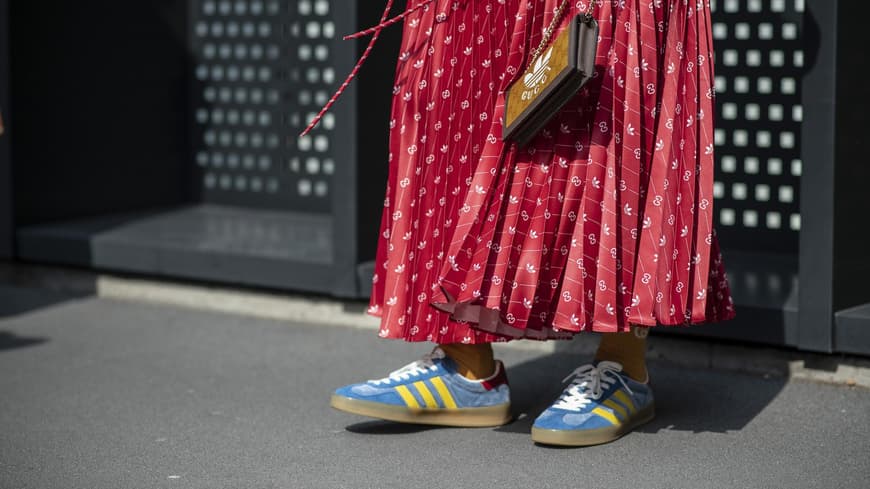 Frau mit rotem Rock und blauen Sneakern
