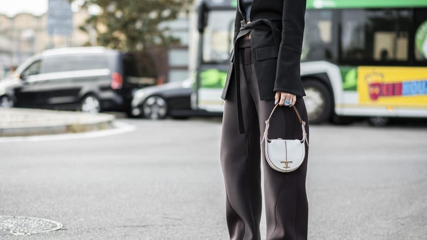 Frau mit Hosenanzug und weißer Tasche