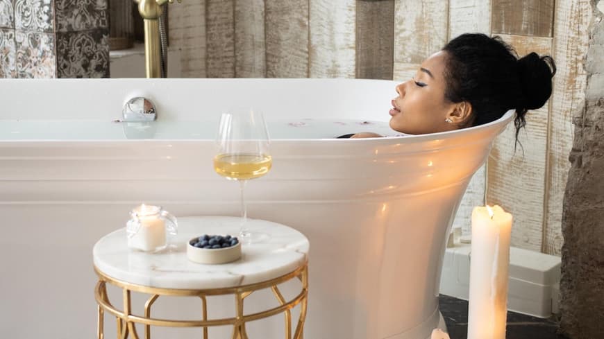 Eine Frau liegt in einer Badewanne im luxuriösen Badezimmer