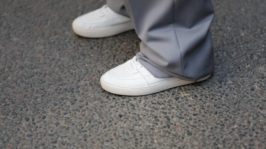 Frau trägt weiße Sneaker mit grauer Hose Streetstyle