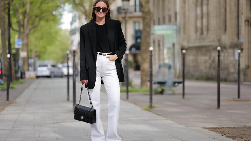 Eine Frau trägt einen Blazer und eine Jeans