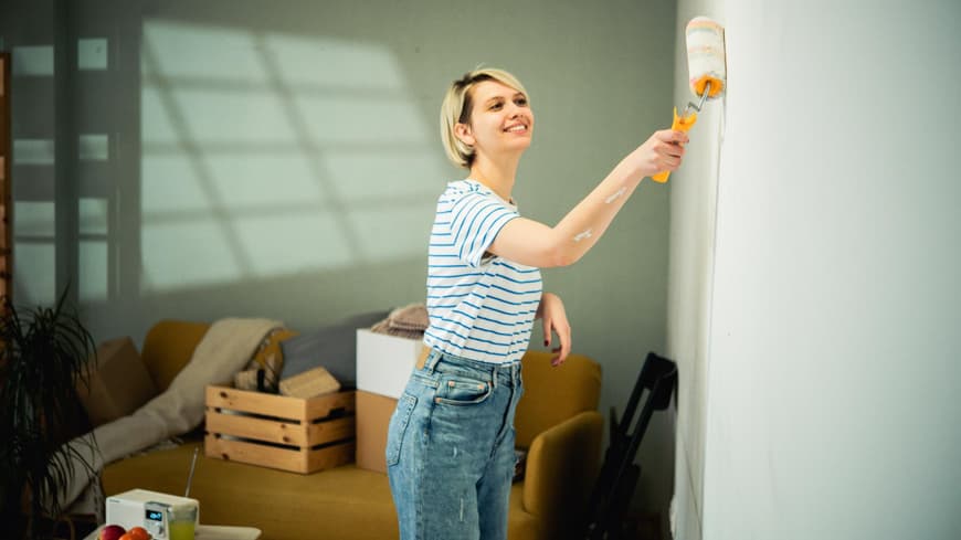 Frau streicht Wand