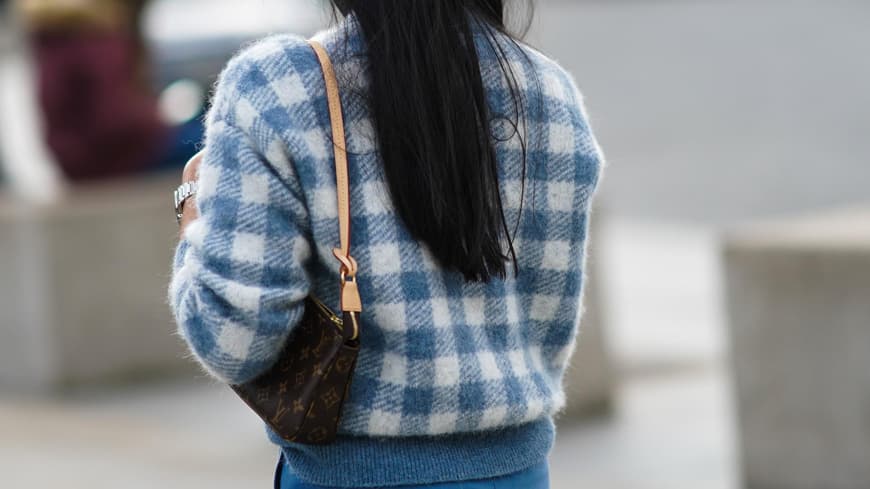 Eine Frau trägt eine Louis Vuitton Monogram Pochette Tasche