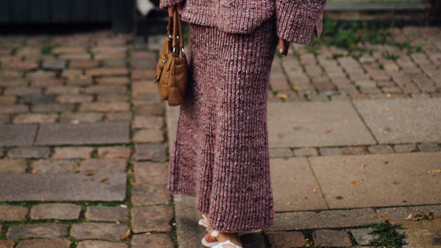 Eine Frau trägt einen langen Strickrock