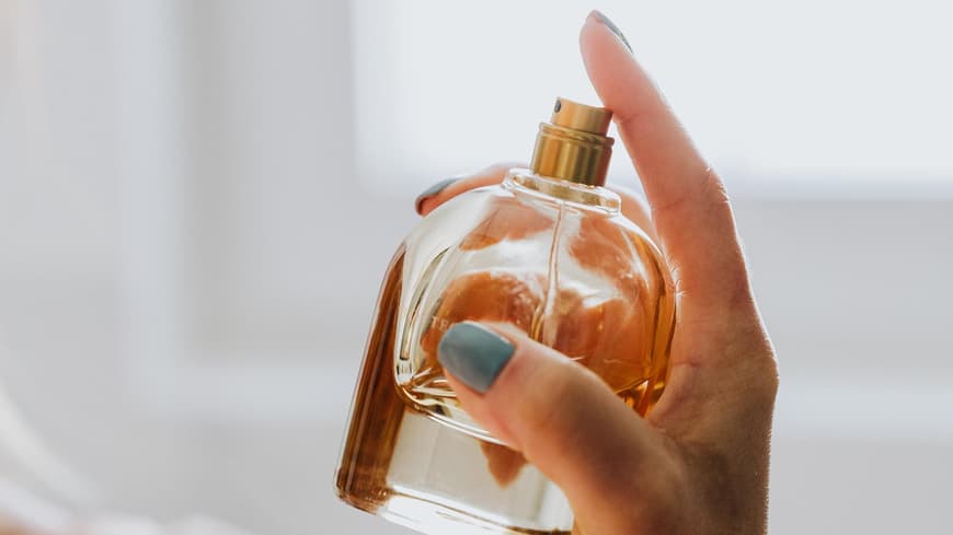 Frau trägt Parfum auf