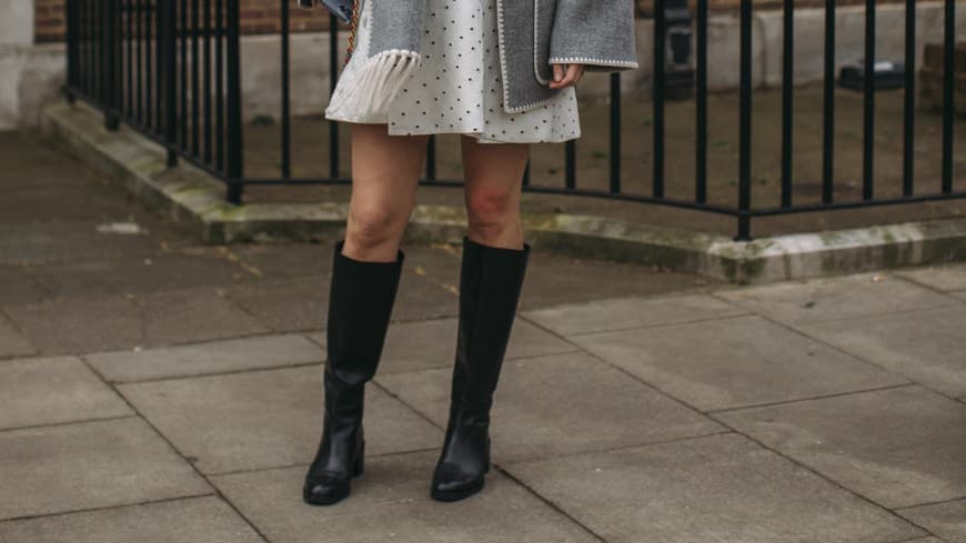 Frau trägt auf Mailand Fashion Week schwarze Stiefel kniehoch