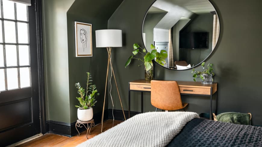Schlafzimmer mit grüner Wand und drei Pflanzen